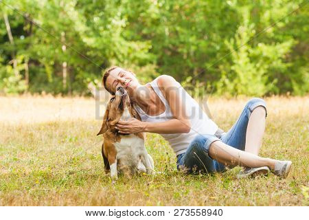 Joyfull Woman And Her Dog In A Summer Meadow