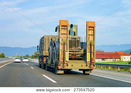 Truck Trailer Transporter With Hauler Carrying Agricultural Tractor On The Highway Road In Slovenia.