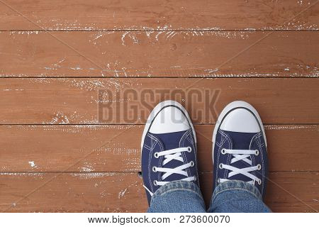 Clothes, Shoes And Accessories - Top View Closeup Legs Put In Gumshoes And Blue Jeans Top View On A 