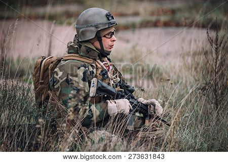 Kyiv, Ukraine - October 14, 2017: Man In Military Uniform Is Sitting In The High Grass During Airsof