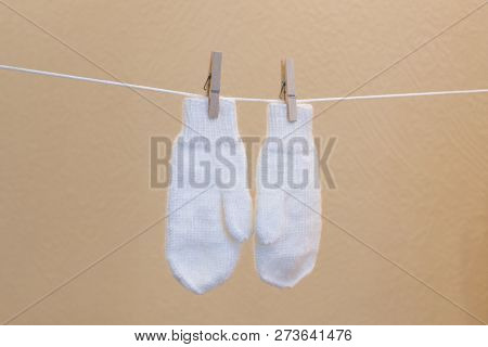White Warm Mittens Hanging From The Clothesline