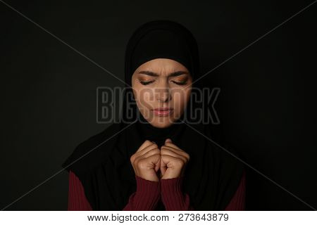 Portrait Of Sad Muslim Woman In Hijab  Praying On Dark Background