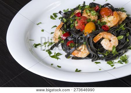 Black Squid Ink Fettuccine Pasta With Prawns Or Shrimps Cherry Tomatoes, Parsley, Chili In Wine And 