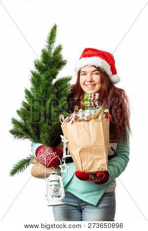 Photo Of Woman In Santa Hat With Christmas Tree, Paper Bag Inhands On Empty White Background
