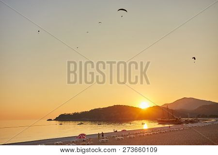 Paraglider Silhouette Flying Over Misty Mountain Valley In Beautiful Warm Sunset Colors - Sport, Act