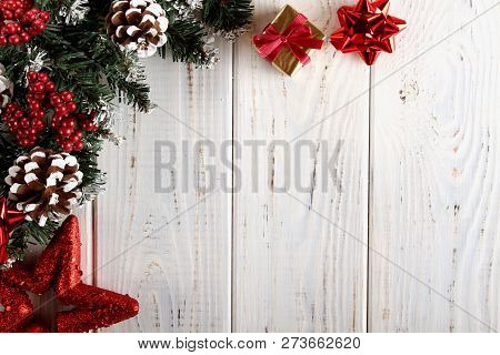 Spruce Branches, Cones And Red Berries On A White Wooden Background. Background For Christmas And Ne