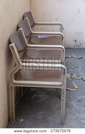 A Close Up Front View Of Three Brown And Cream Connected Seats Outside In A Designated Area