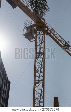 A Close Up View From The Ground Of A Yellow Crane Working On A Construction Site With A The Conner O