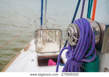 Winch Mounted On The Mast With Ropes Wound Around It Against The Background Of An Open Hatch In Fron