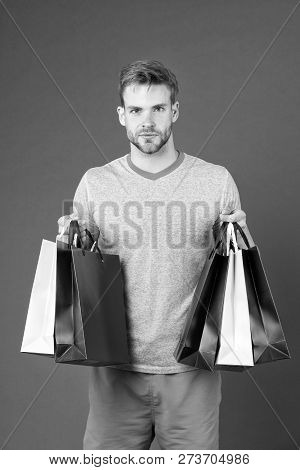 Capture Opportunity. Man Bearded Face Holds Shopping Bags. Guy Bought Lot Sporty Clothes And Accesso