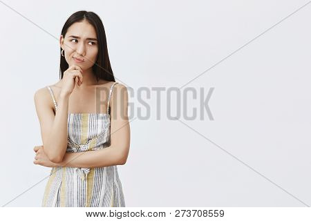 Hmm, Let Me Think. Portrait Of Doubtful Good-looking Asian Female In Matching Trendy Outfit, Smirkin