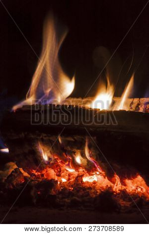 Flames From Carbonized Wood In The Darkness