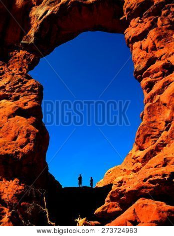 Silhouette of hiker in arch canyon rock formations