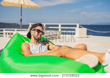 Young Man Enjoying Leisure, Lying On The Air Sofa Lamzac, Near The Sea