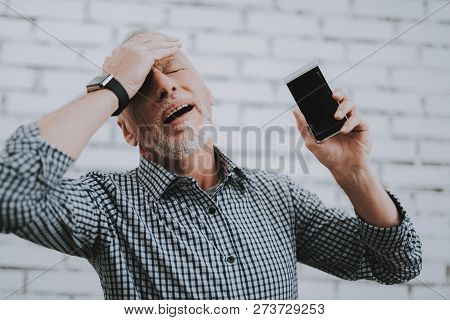 человек держится за голову глядя в телефон