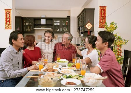 Happy Big Asian Family Sitting At Dinner Table And Celebrating Lunar New Year, Couplets With Best Wi