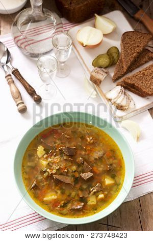 Rassolnik, Traditional Russian Soup, Served With Various Snacks And Vodka. Rustic Style.