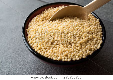 Raw Dry Organic Couscous In A Bowl With Wooden Spoon / Turkish Kuskus