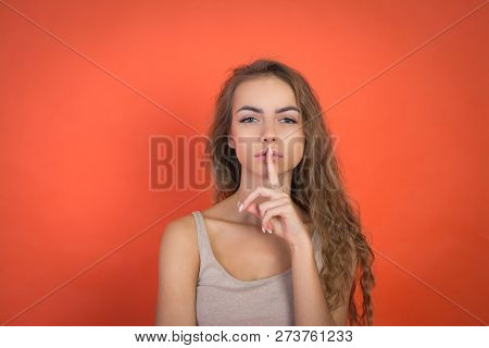Lips And Hand Of Beautiful Young Girl Doing Silence Sign Tss Gesture Isolated On Red Background With
