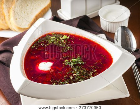 Ucrainian Russian Traditional Beetroot Soup - Borsch In Triangular White Plate On Dark Brown Wooden 