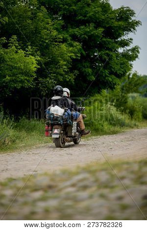 Man Riding Motorcycle With A Woman On Rural Road. Young Couple On Motorbike Through Country Road. Co