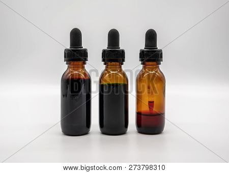 Three Amber Glass Bottles With Dropper Isolated On White Background.