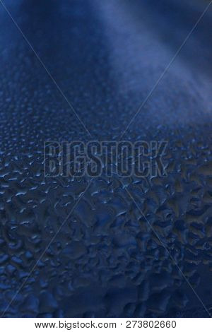 Drops Of Water Run Down The Blue Glass