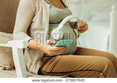 Pregnant Woman Tuning On A Lullaby For Her Future Baby