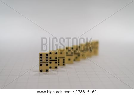 Row Of Yellow Domino Pieces Or Blocks On The White Background With The First Piece In Focus