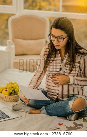 Pregnant Woman Carefully Reading The Working Paper