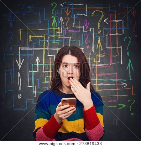 Confused Young Woman Using Her Phone Shocked Open Mouth Emotion. Human Reaction Concept As Different