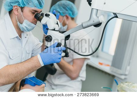 Doctor Used Microscope. Dentist Is Treating Patient In Modern Dental Office. Operation Is Carried Ou