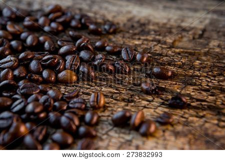 Coffee Beans On Wood Background. Coffee Cup Full Of Coffee Beans.