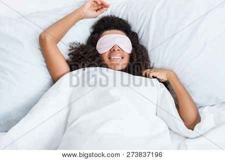 Joyful African American Girl With Eyes Covered By Sleeping Blindfold In Bed During Morning Time At H