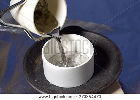 Pouring Molten Lead In Ceramic Ware. Heat-resistant Ceramics