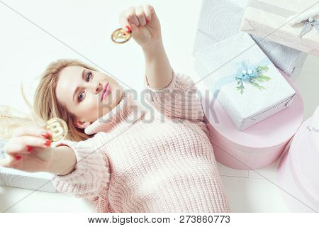 Woman Lying Down Holding Coins Bitcoins. Next To Her Are Gifts.