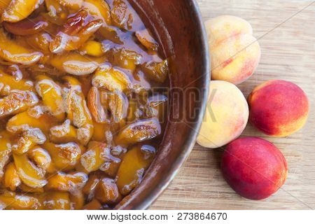 Fresh Bright Peaches And Nectarins Lay On The Stone Bricks, Close To The Copper Jar, Full Of Peach J