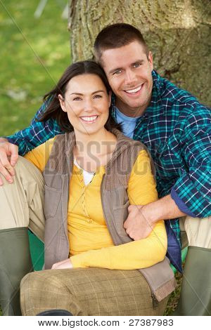 Couple sitting gegen Baumstamm