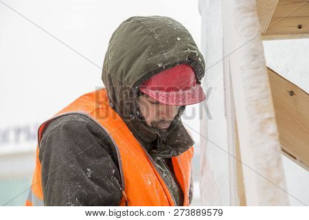 Worker Fitter In A Protective Helmet And Reflective Vest On The Working Meast
