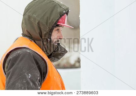 Worker Fitter In A Protective Helmet And Reflective Vest On The Working Meast