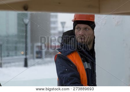 Worker Fitter In A Protective Helmet And Reflective Vest On The Working Meast