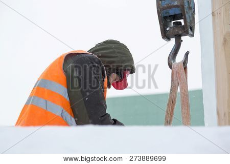 Worker Fitter In A Protective Helmet And Reflective Vest On The Working Meast