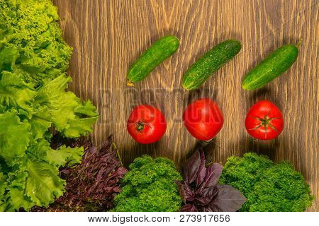 Fresh Vegetables. Tomatoes And Cucumbers On A Wooden Table. Seasoning For The Kitchen