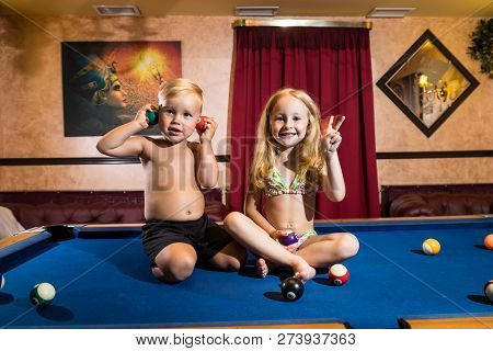 Kirov, Russia - July 18, 2018: Cute Children Sitting On The Billiards Table And Balls Arround. Baref