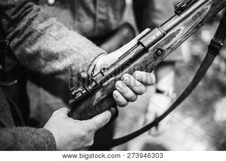 Re-enactor Dressed As World War Ii German Soldier Holding Rifle. Photo In Black And White Colors. So