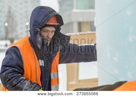 Worker Fitter In A Protective Helmet And Reflective Vest On The Working Meast