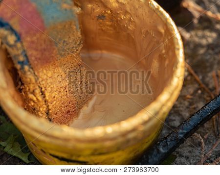 Plastic Bucket With Old Bath Puff, Close Up View. Bucket With Golden Paint On The Ground. Vintage Ba