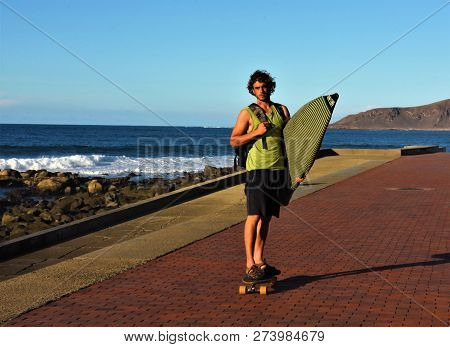 Gran Canaria, Spanien, November 2018, Ein Junger Mann Auf Einem Skateboard Mit Surfbrett An Der Prom