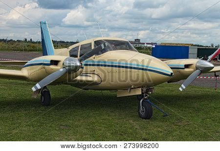 The Two Engine Plane Stands On The Green Grass In A Cloudy Day. A Small Private Airfield In Zhytomyr