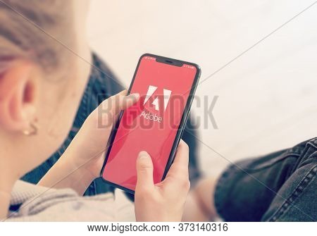 Kyiv, Ukraine-january, 2020: Adobe On Mobile Phone Screen. Young Girl Pointing Or Looking On Adobe S